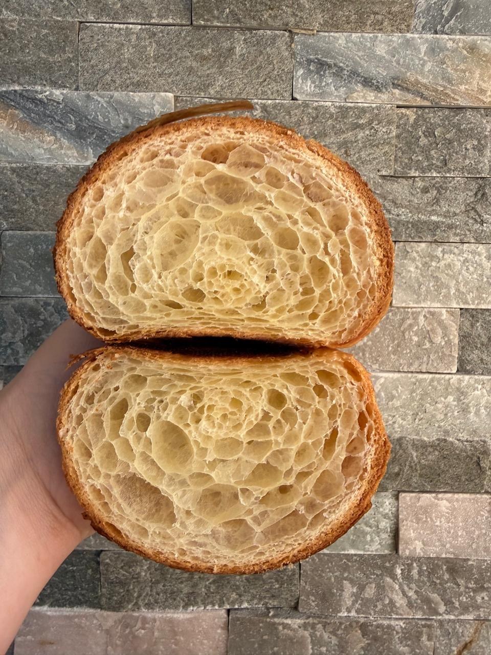 Dos mitades de un croissant que muestran una miga alveolada